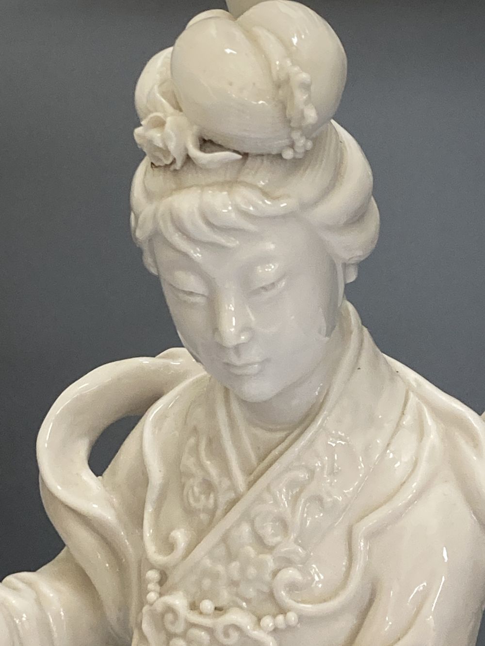 A Chinese blanc de chine porcelain table lamp, modelled as Guanyin, 65cm high including shade and a toleware vase shaped table lamp (2)